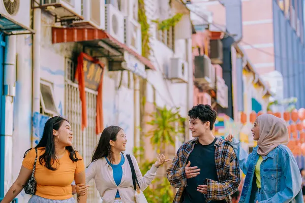 Man with a white backpack looking at a busy shopping street in Malaysia