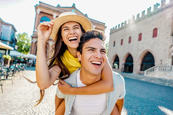 Man giving a woman a piggyback through Milan