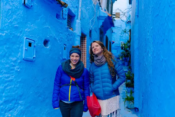 Women in blue jackers walking through a bright blue corridor