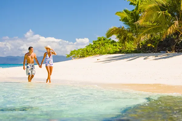 Couple walking hand in hand on a beach