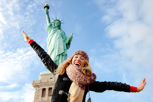 Woman posing in front of the Statue of Liberty