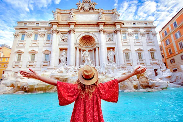 Woman spreading her arms looking at the Trevi Fountain