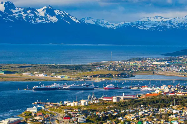 Drone shot of city with snow-capped mountains in background