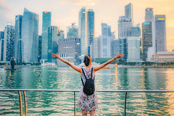 woman with arms out standing near water in singapore