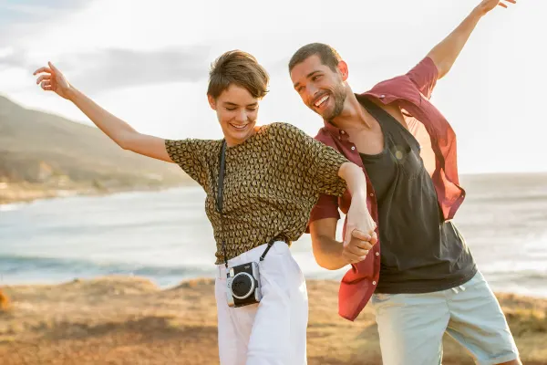 Couple posing for a photo in front of a beach in South Africa
