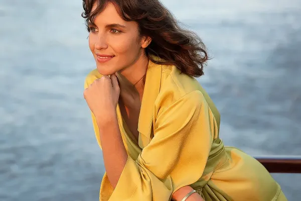 Lady looking over balcony in yellow dress