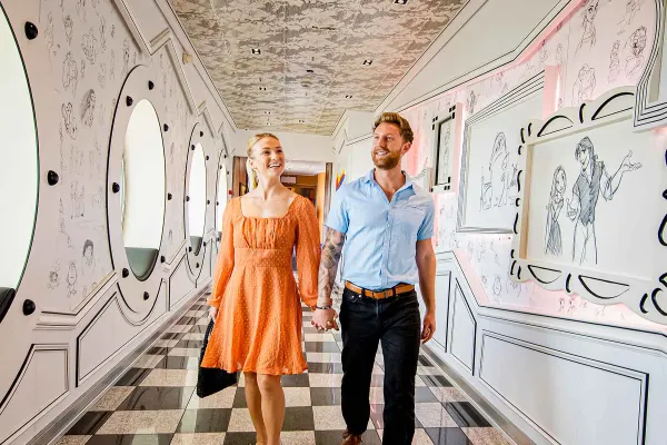 Two people walking through ship with black and white checkered floors