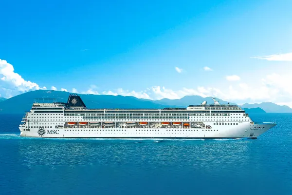 Cruise ship with mountain range and clouds in distance
