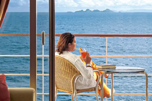 Lady drinking a cocktail on her cabin baclony