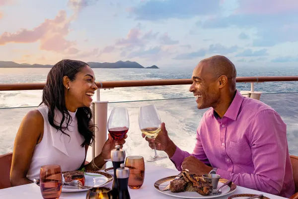 Couple dining outside with sun setting in background