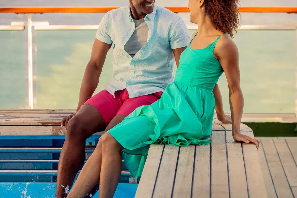 Couple sitting on pool edge with feet in water