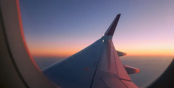 Sunset view from window over the wing of a commercial plane