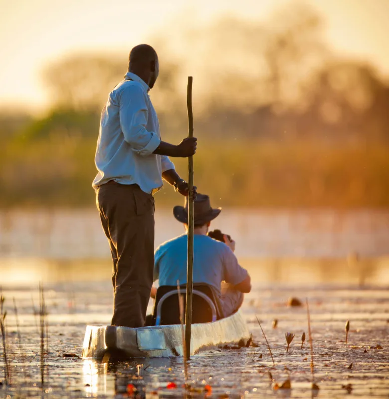 Travelling through the Okavango Delta in a traditional Mokoro on a luxury travel holiday to Botswana.