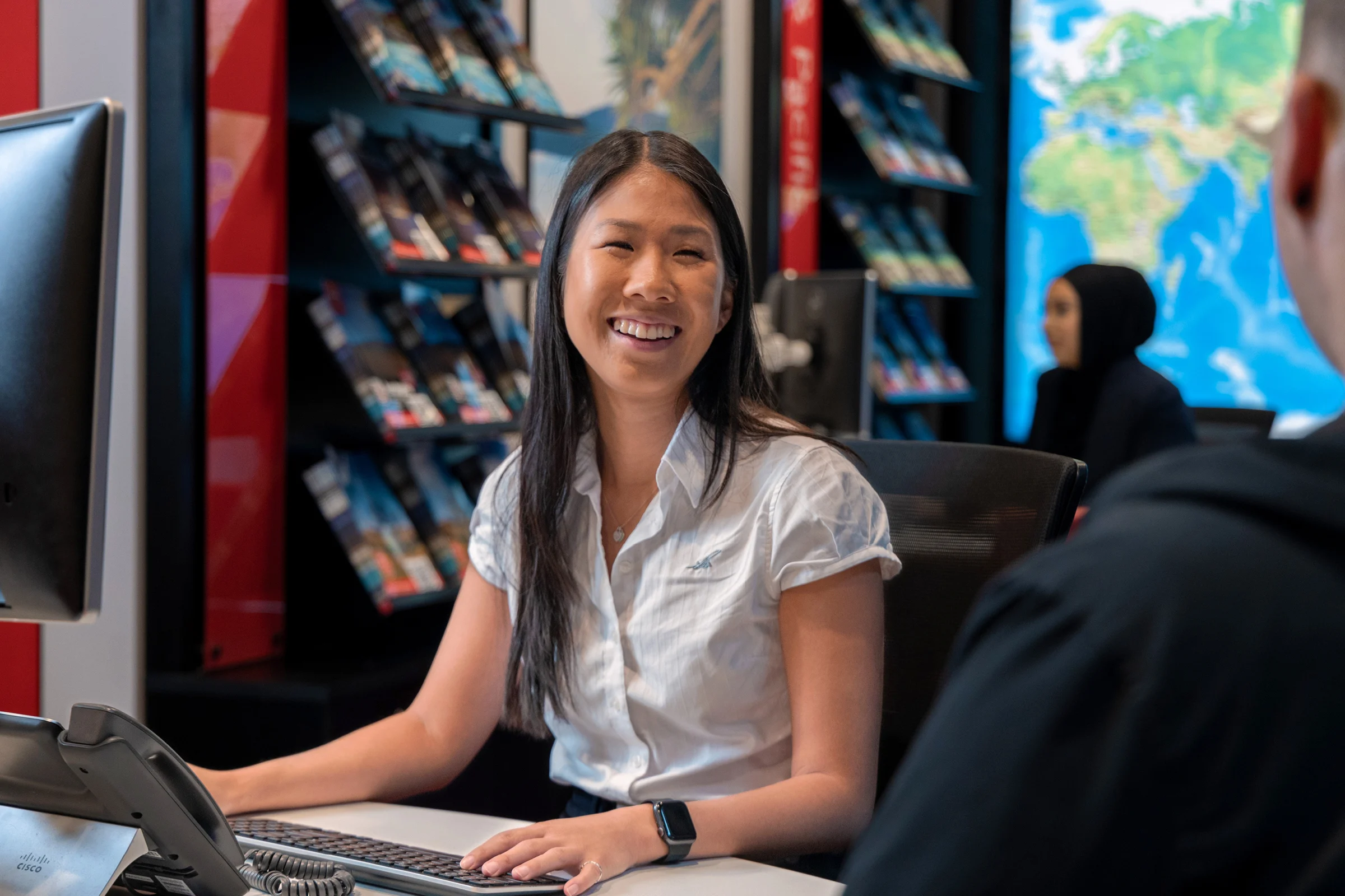 Flight Centre travel agent smiling at work