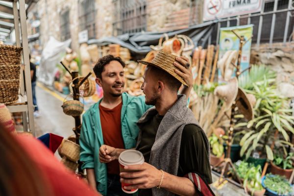 Gay couple trying on hats at a street market in Bogota