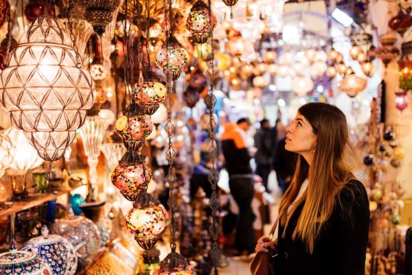 Young woman looking at lights at a market stall in Istanbul, Turkey