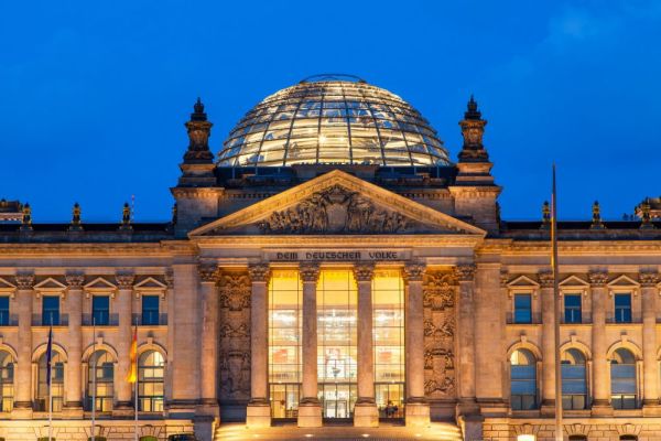 Night shot of the Reichstag, Berlin with lights shining through the entrance windows