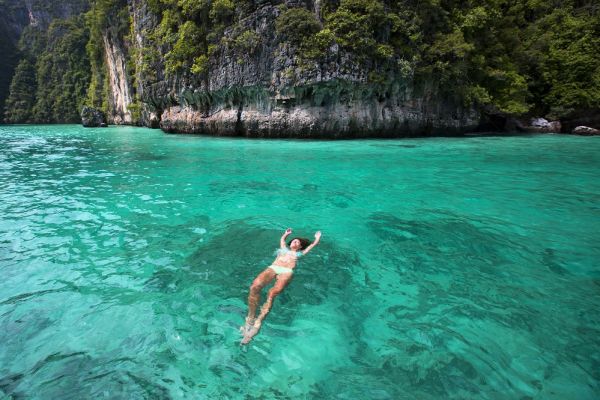 Female floating in crystal clear water