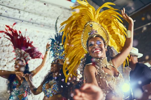 Dancers wearing colourful costumes during night life carnival with confetti falling