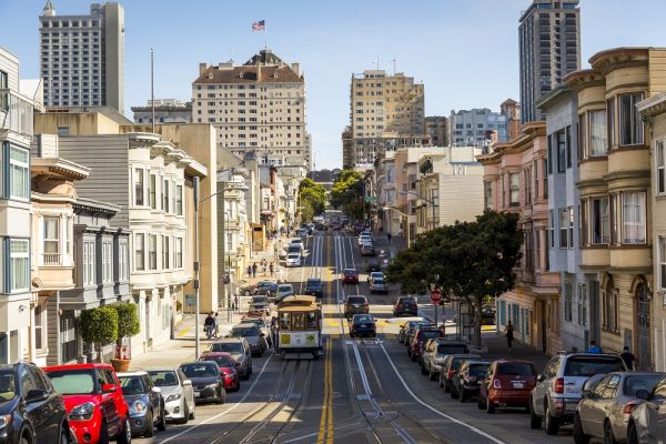 Cable car and cars going through the city of San Francisco