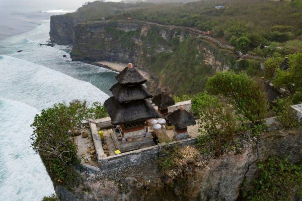 Temple on edge of mountain over looking ocean waves