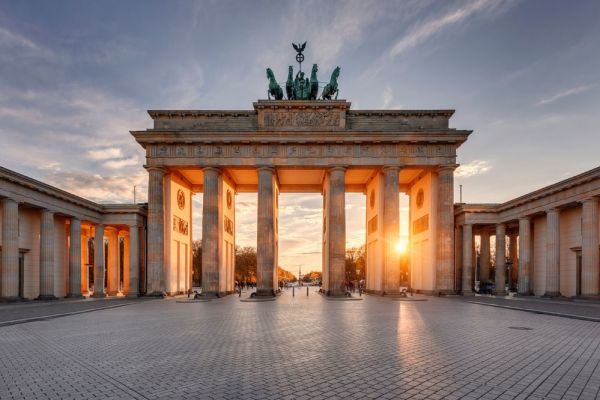 Wide shot of the sun peeping through a gap in the Brandenburg Gate