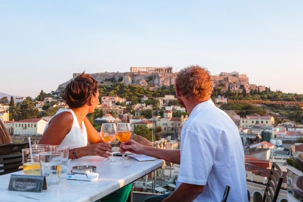 Couple at a table overlooking Athen building at sunset