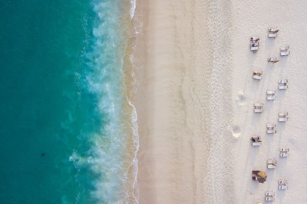Birds eye view of a beach with rows of beach chairs in Los Cabos