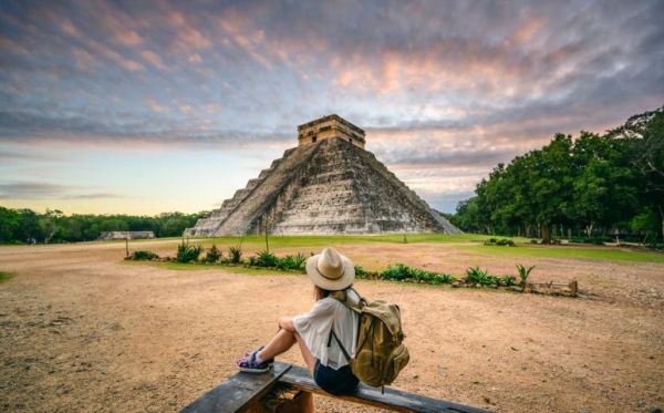 woman sitting infront of Mayan pyramid