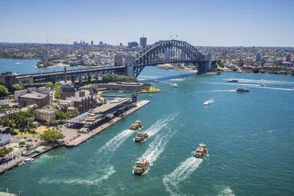 Wide shot of Sydney Harbour Bridge with boats floating past
