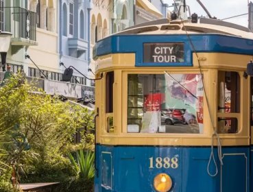 A tram passes through a pretty side street in Christchurch