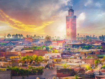 View of marrakesh city with sun shining behind clouds in the background