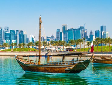 A dhow boat moored with the Doha cityscape in the background