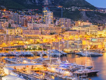Marina lite up with city lights dusk time, Monaco