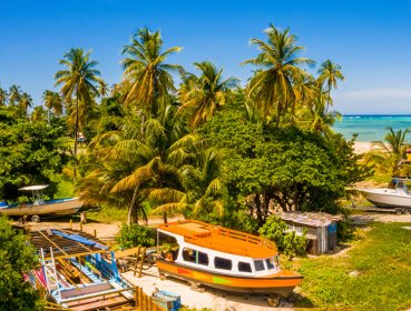 A beach located in Seychelles that has several boats on land as well as on the shore line
