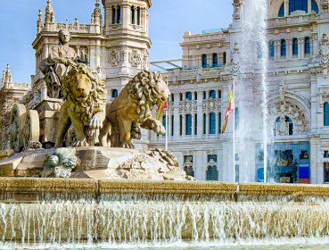 Close up of the lions on the Cibeles Fountain with palace in background