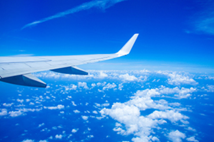 Wing of a plane with clouds