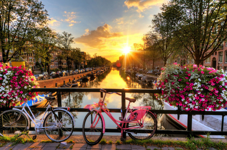 Sunset over canal with bikes in Amsterdam