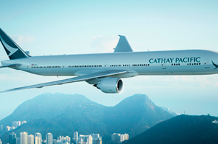 Cathay Pacific plane flying over a city