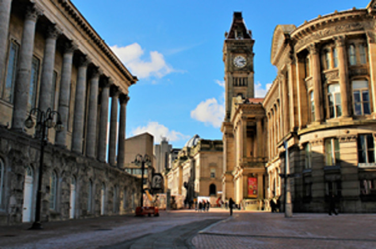 buildings of birmingham with blue skies and sunshine showing in between