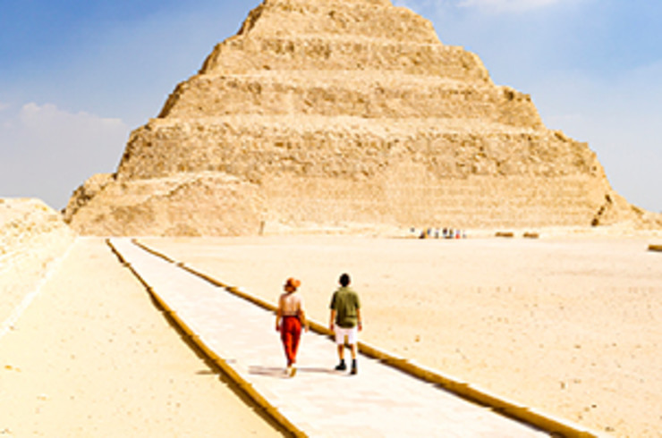 two people walking towards pyramid in egypt 