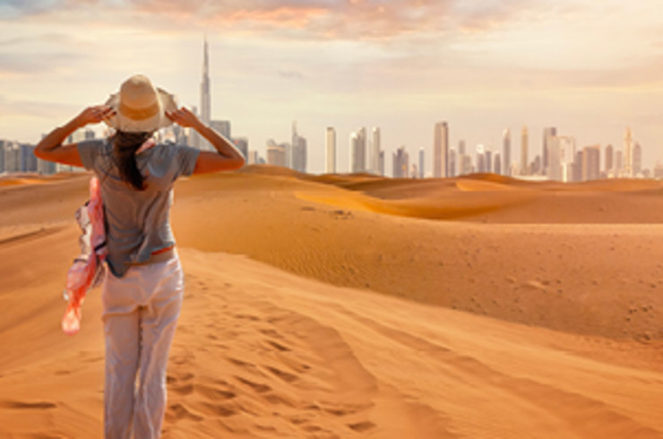 Standing in the Dubai desert looking at the city skyline in the distance