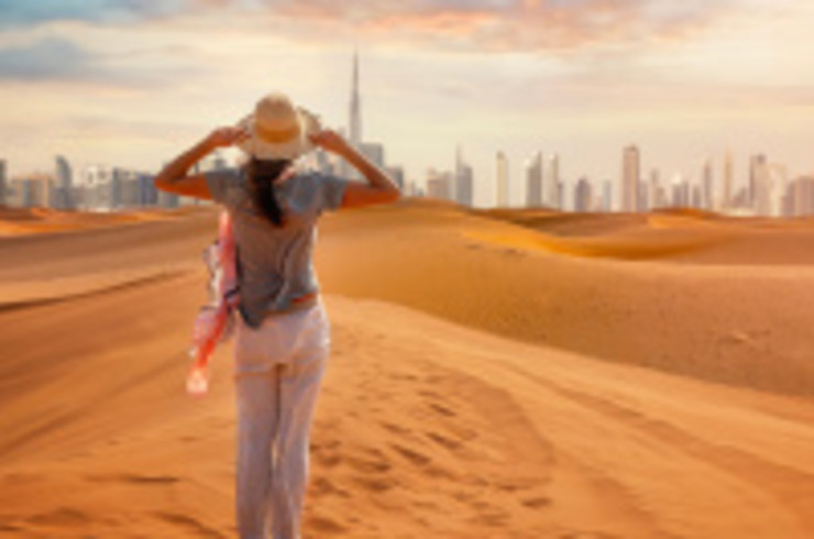 Standing in the Dubai desert looking at the city skyline in the distance