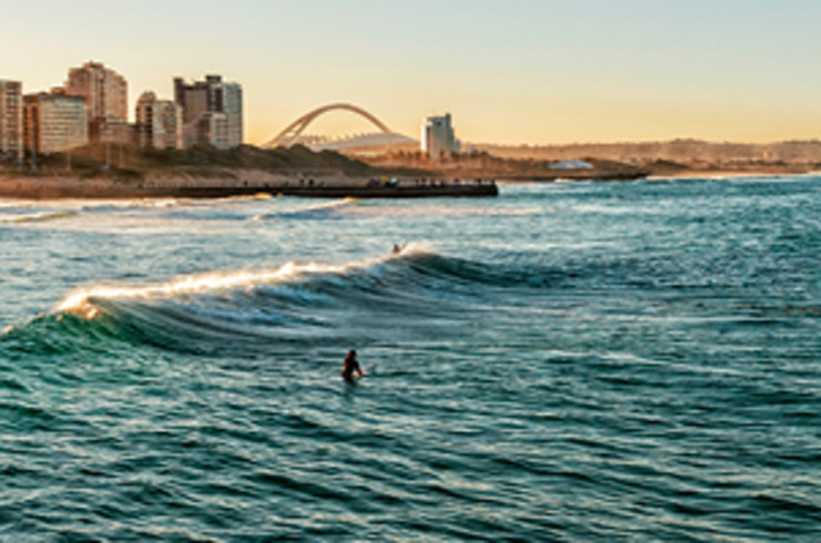 Surfing waves in Durban with city in background