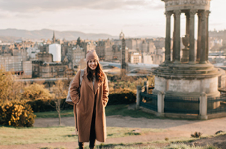 lady standing in front of stone structures in edinburgh