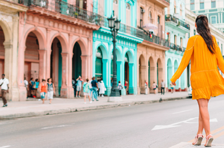 lady in yellow dress walking across road in havana