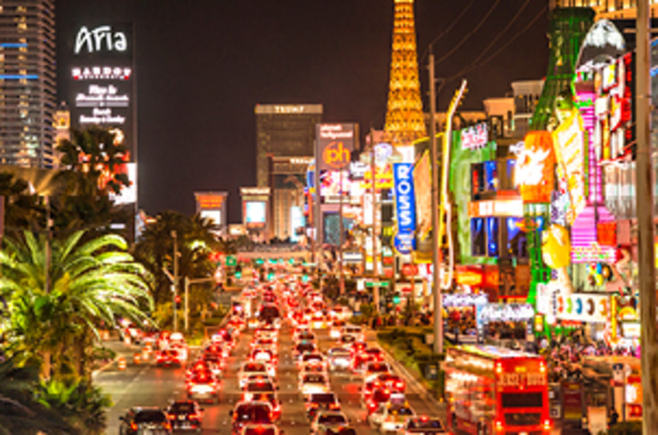 vegas city at night, streets lined with bright buildings and roads full of traffic