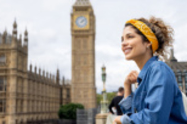 A women enjoys a view of London's Big Ben and House of Parliament, which can be seen with a flight to London that arrives and departs from Heathrow Airport.