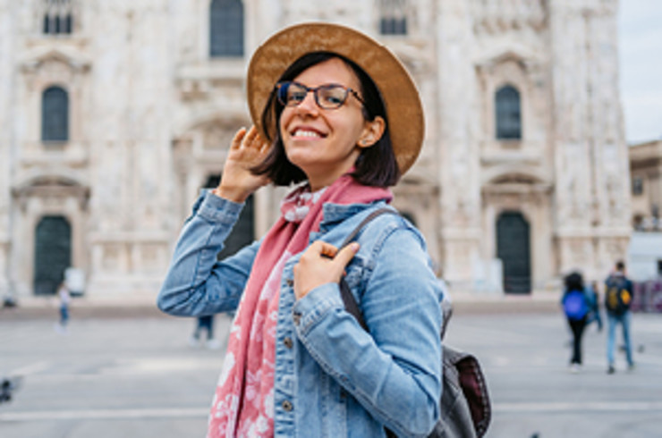 lady with hat standing outside building in milan smiling