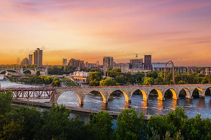 minneapolis city at sunset with a long bridge over a river